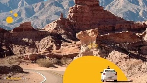 Formaciones rocosas rojas en la Quebrada de las Conchas con auto en carretera.