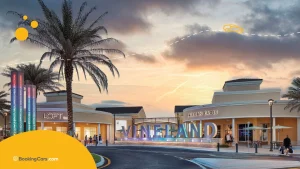 Entrada del Vineland Premium Outlets en Orlando al atardecer con palmeras.
