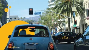 Autos circulando por una avenida de Los Ángeles con cartel que indica “Hollywood”.