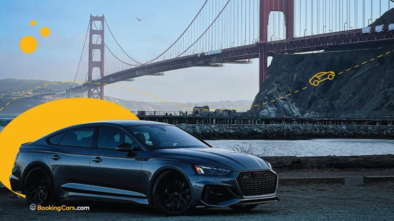 Auto estacionado cerca del Puente Golden Gate con un paisaje de fondo y cielo despejado.