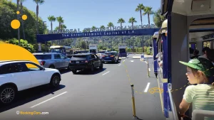 Entrada a Universal Studios Hollywood con autos y visitantes en la fila.