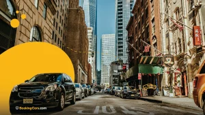 Calle de Nueva York con autos estacionados y rascacielos al fondo.