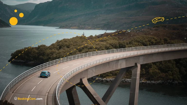 Auto cruzando un puente curvo sobre un lago en un paisaje montañoso europeo.