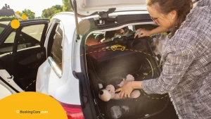 Madre acomodando equipaje y juguetes en el baúl de un auto familiar.
