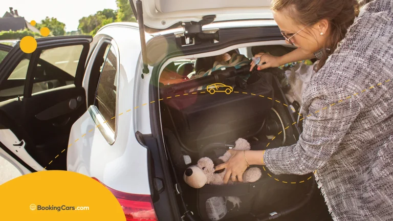 Madre acomodando equipaje y juguetes en el baúl de un auto familiar.