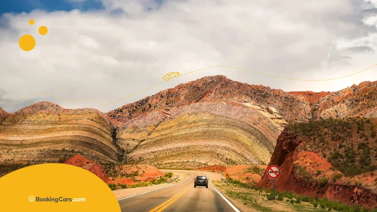 Ruta hacia montañas multicolores con logo de BookingCars.